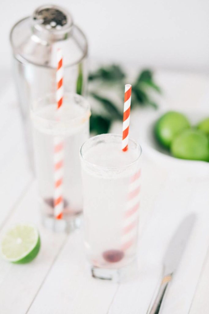 Two glass of detox ice tea with red and white straws